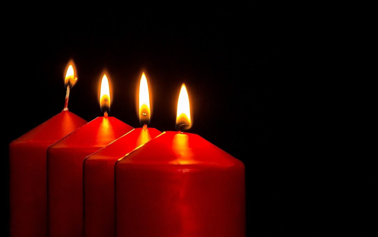 Red candles burning against a dark background